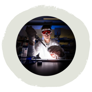 student pipetting in a laboratory wearing proper PPE