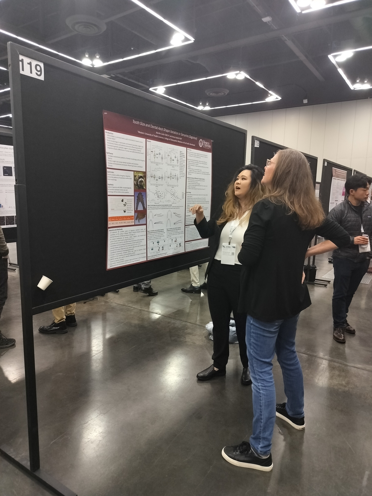 Mariko Locke presents her poster to a conference attendee