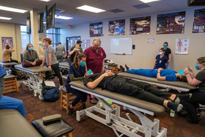 Dr. Goering is teaching students cranial techniques in the OMM lab at COMP NW