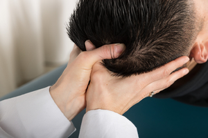 Osteopathic physician performing cranial OMT on a patient
